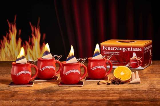 Zu sehen ist Feuerzangen 4er Set in rot. Beide Tassen sind mit der Feuerzangentassenbowle befllt und mit einem brennenden Zuckerhut bestck